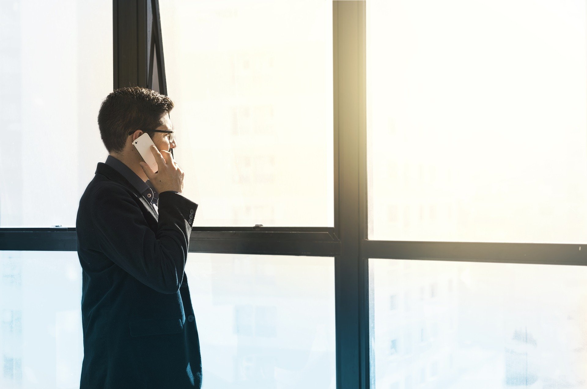 man on cellphone in front of window PEO companies Tampa